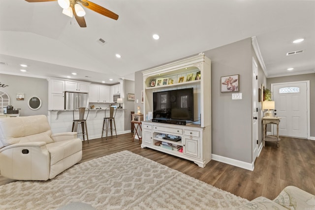 living room featuring visible vents, ornamental molding, wood finished floors, and vaulted ceiling