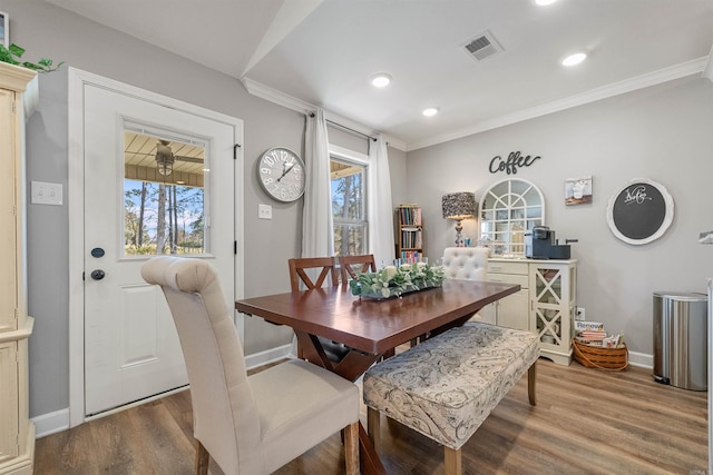 dining room featuring a wealth of natural light, visible vents, baseboards, and wood finished floors