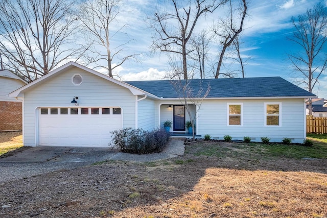 ranch-style home featuring driveway, a shingled roof, an attached garage, and fence