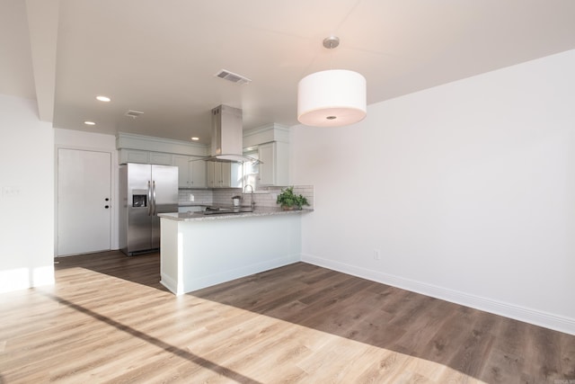 kitchen featuring visible vents, island exhaust hood, backsplash, dark wood finished floors, and stainless steel fridge with ice dispenser