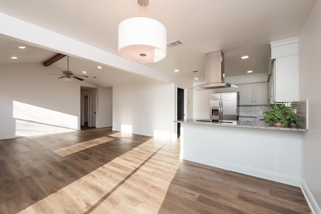 kitchen featuring visible vents, stainless steel refrigerator with ice dispenser, island exhaust hood, tasteful backsplash, and wood finished floors