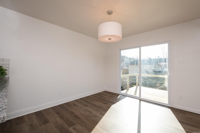 empty room featuring dark wood finished floors and baseboards