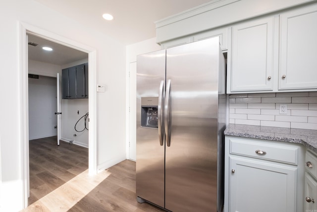 kitchen featuring light wood-style flooring, backsplash, recessed lighting, stainless steel fridge with ice dispenser, and light stone countertops