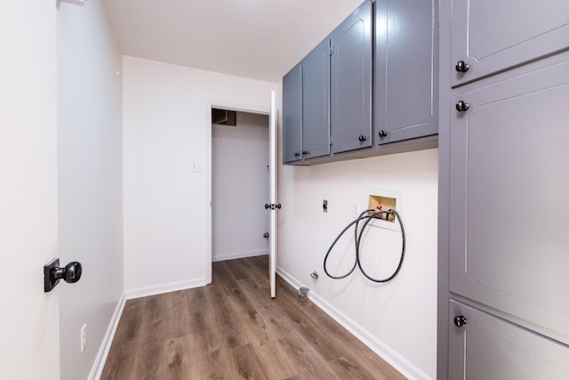 laundry room with wood finished floors, cabinet space, baseboards, hookup for an electric dryer, and hookup for a washing machine