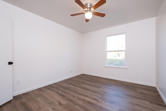 unfurnished room featuring dark wood finished floors, a ceiling fan, and baseboards