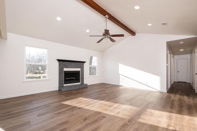 unfurnished living room with visible vents, a healthy amount of sunlight, lofted ceiling with beams, and wood finished floors