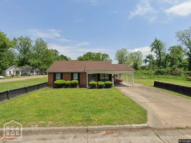 ranch-style house with driveway, an attached carport, a front lawn, and fence