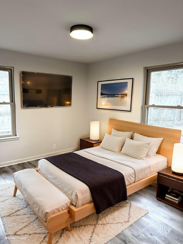 bedroom featuring baseboards and wood finished floors