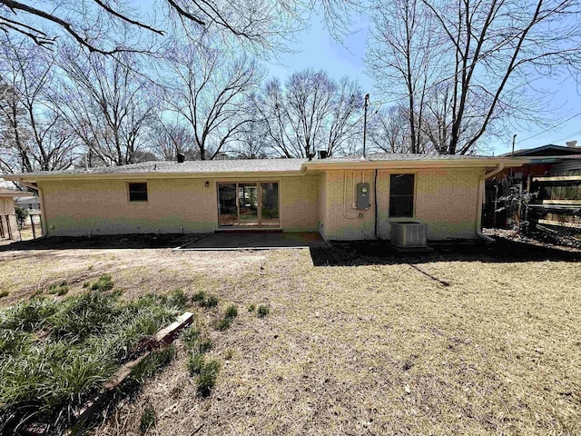 back of property with brick siding, central air condition unit, and a patio