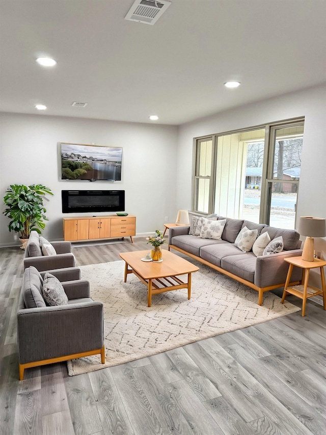 living area featuring visible vents, recessed lighting, and wood finished floors