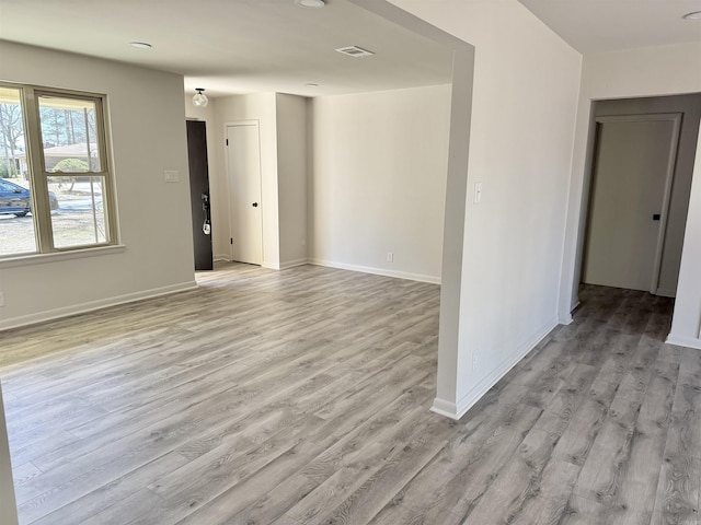 unfurnished room featuring visible vents, baseboards, and light wood-style floors