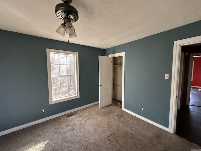 unfurnished bedroom with baseboards, visible vents, a closet, a textured ceiling, and carpet flooring