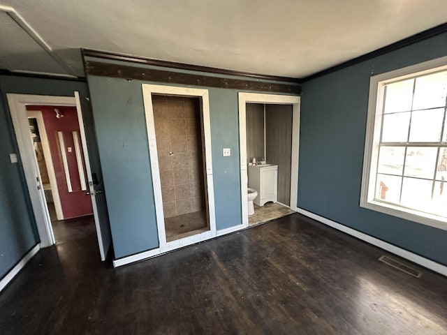 unfurnished bedroom featuring visible vents, ornamental molding, and wood finished floors