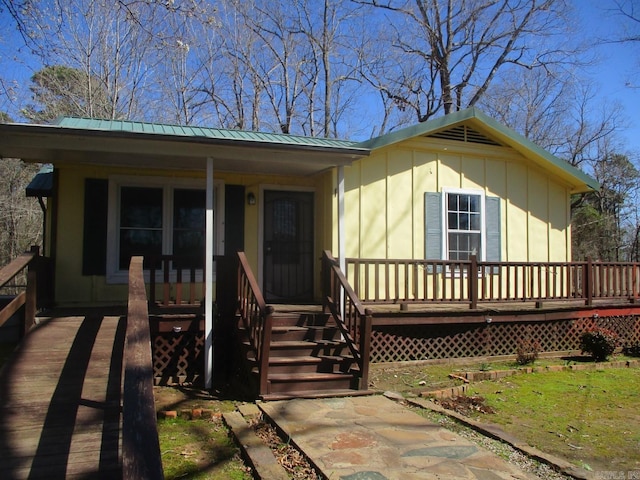 view of front facade featuring board and batten siding, covered porch, and metal roof