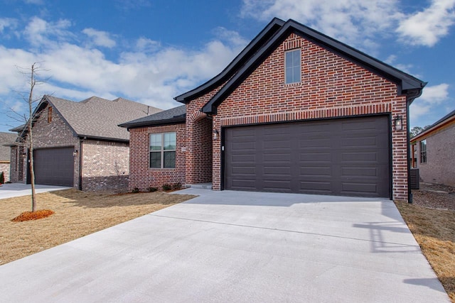 single story home featuring a garage, brick siding, and driveway