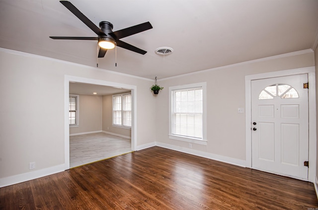 foyer with crown molding, visible vents, ceiling fan, baseboards, and wood finished floors