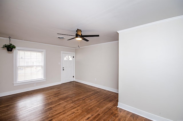 empty room with visible vents, dark wood finished floors, and crown molding