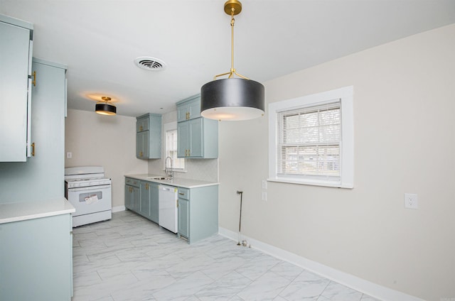 kitchen with marble finish floor, a sink, white appliances, light countertops, and baseboards