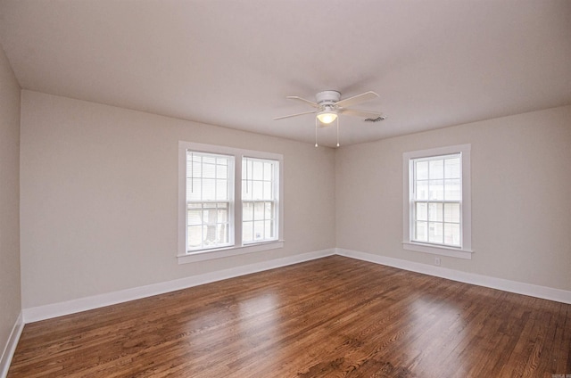 unfurnished room with ceiling fan, dark wood-type flooring, and baseboards