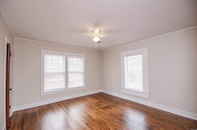 spare room with a ceiling fan, dark wood-type flooring, crown molding, and baseboards