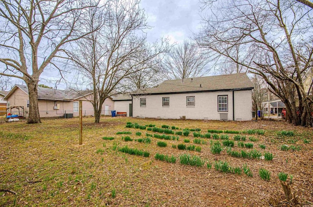 back of house with crawl space, brick siding, and fence