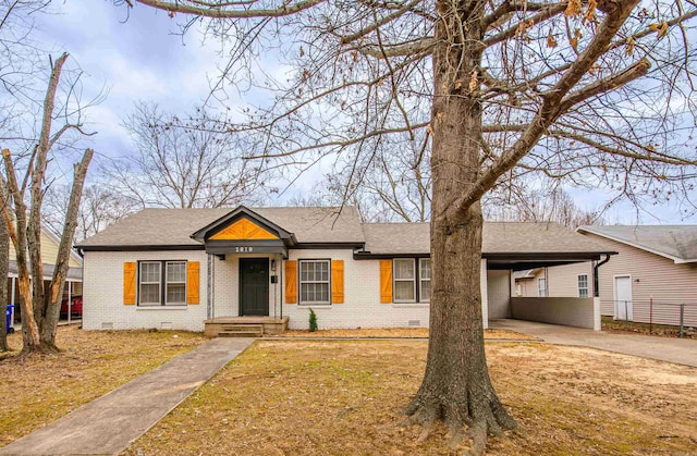 view of front of home featuring brick siding, an attached carport, a shingled roof, crawl space, and driveway