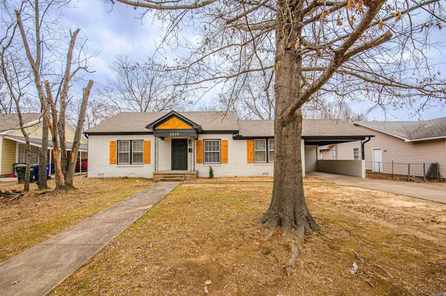 view of front of home with a carport, brick siding, driveway, and crawl space