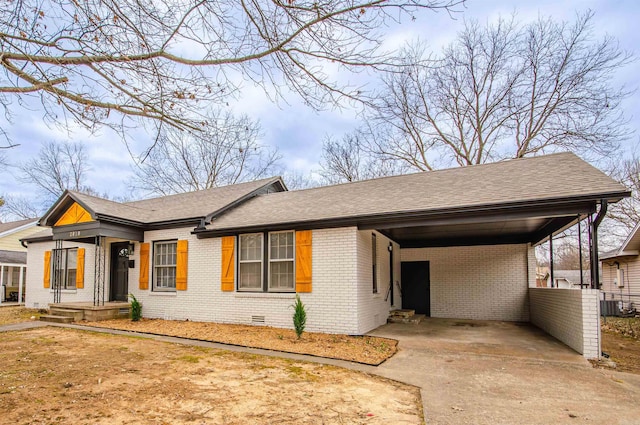 single story home featuring a carport, concrete driveway, a shingled roof, crawl space, and brick siding