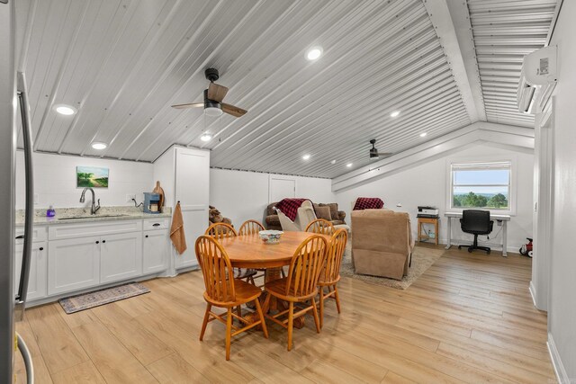 dining area featuring ceiling fan, lofted ceiling, an AC wall unit, and light wood-style flooring