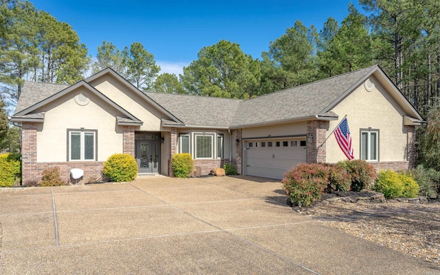 ranch-style home with roof with shingles, a garage, driveway, and stucco siding