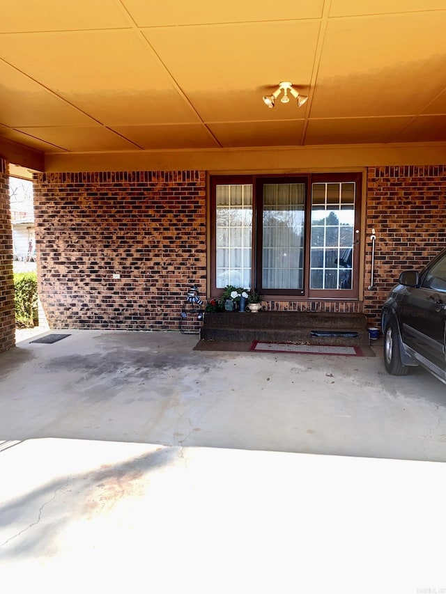 view of exterior entry with brick siding