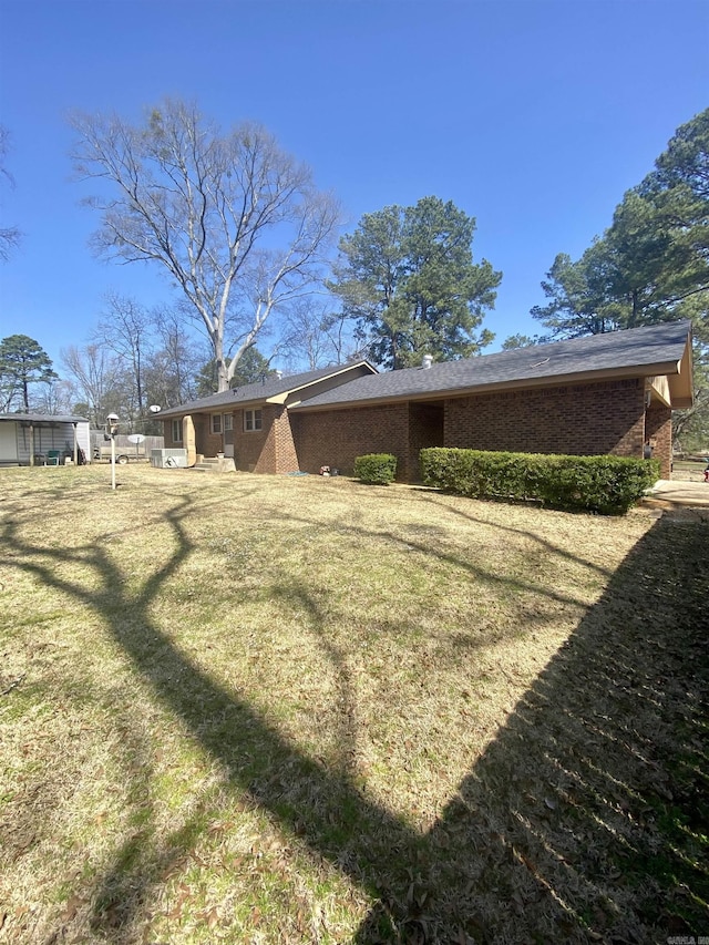 rear view of house with a yard and brick siding