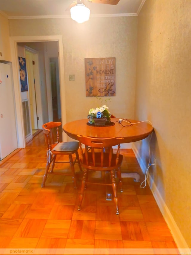 dining space with baseboards and crown molding