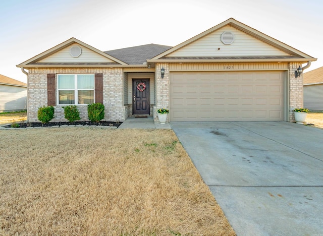 single story home with brick siding, an attached garage, concrete driveway, and a front yard