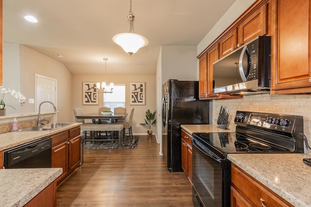 kitchen with dark wood finished floors, black appliances, brown cabinets, and a sink