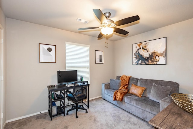 carpeted office space featuring baseboards, visible vents, and ceiling fan