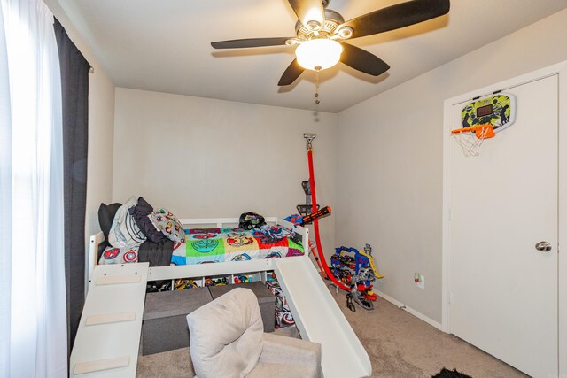 carpeted bedroom featuring baseboards and a ceiling fan