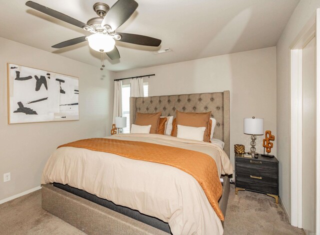 carpeted bedroom with visible vents, baseboards, and ceiling fan