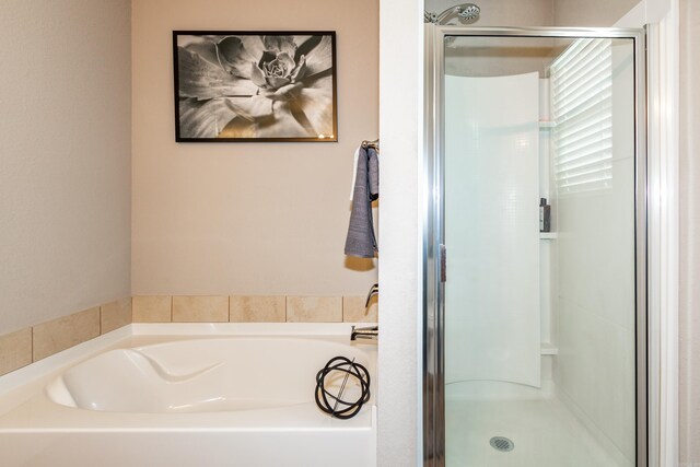 full bathroom featuring a garden tub and a stall shower