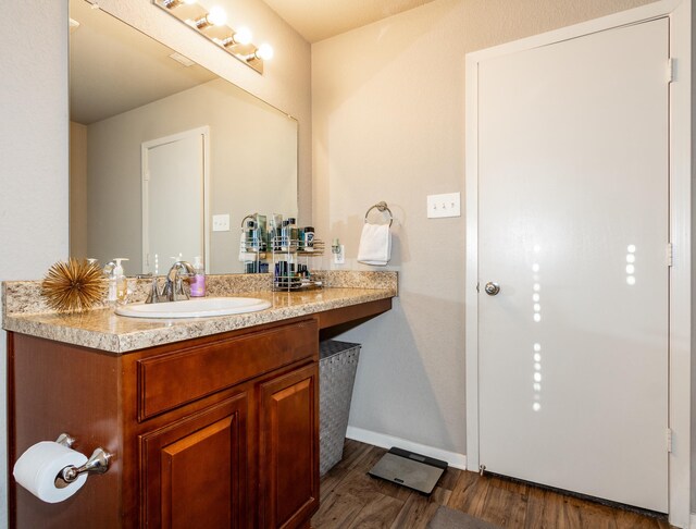 bathroom with vanity, baseboards, and wood finished floors