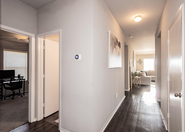 hall featuring dark wood finished floors and baseboards