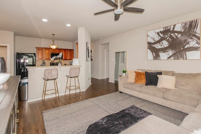 living room with a ceiling fan, recessed lighting, dark wood-style floors, and baseboards