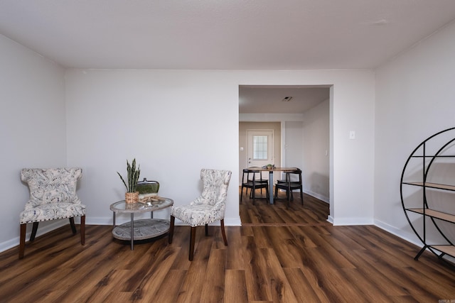 sitting room with baseboards and wood finished floors