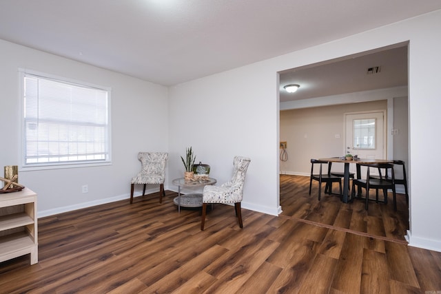 living area with visible vents, wood finished floors, and baseboards