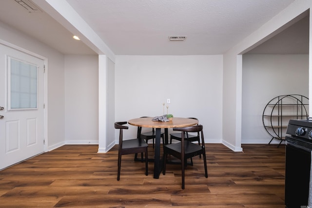 dining room featuring visible vents, baseboards, and dark wood-style flooring