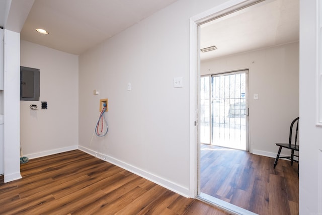 laundry area with electric panel, wood finished floors, visible vents, and baseboards