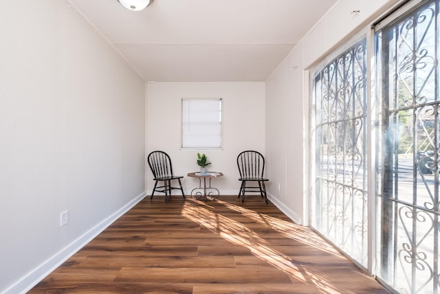 sitting room featuring baseboards, plenty of natural light, and dark wood-type flooring