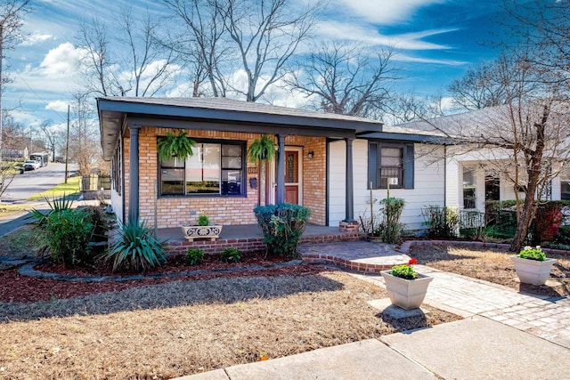 view of front of house featuring a porch and brick siding