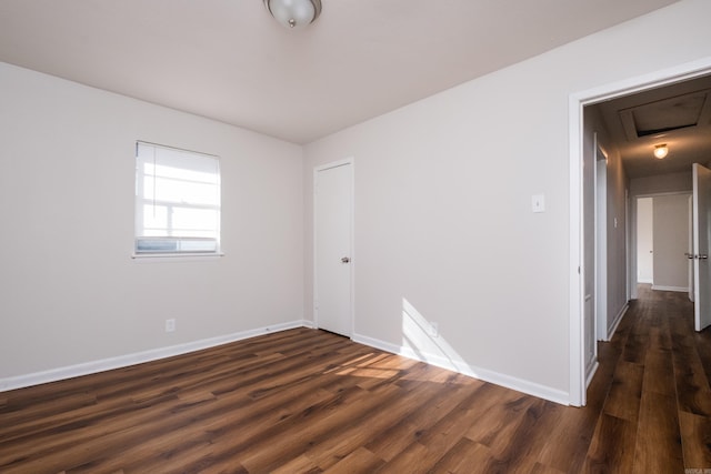 empty room with dark wood-style floors and baseboards