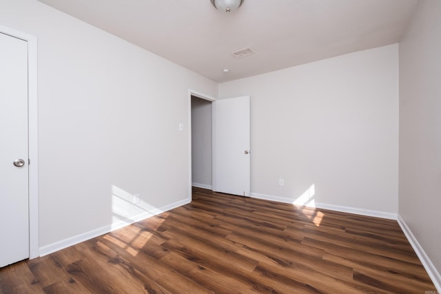 empty room with visible vents, wood finished floors, and baseboards